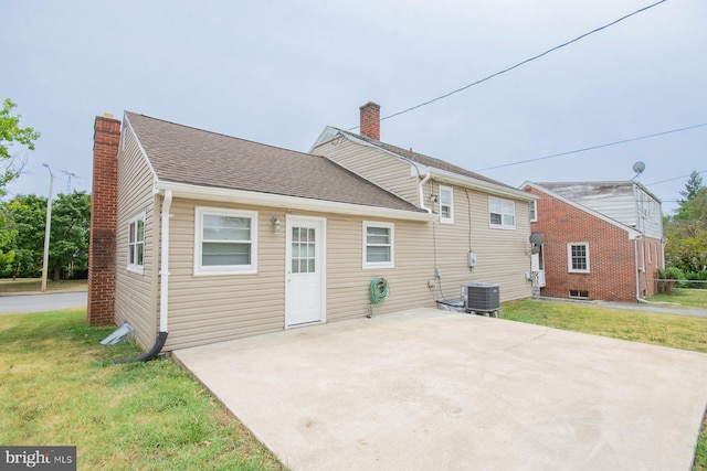 rear view of house with a lawn, central AC unit, and a patio area