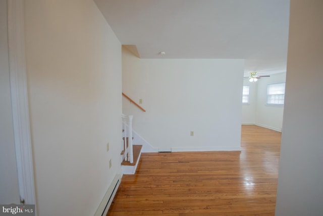 stairway with hardwood / wood-style flooring and ceiling fan