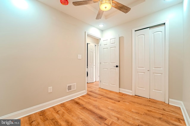 unfurnished bedroom featuring ceiling fan, light hardwood / wood-style floors, and a closet