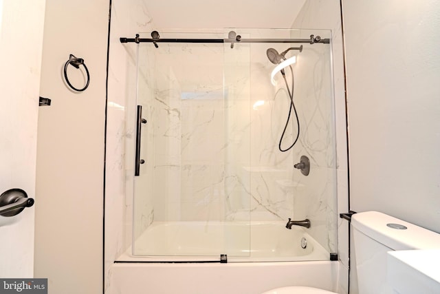 bathroom with toilet and combined bath / shower with glass door