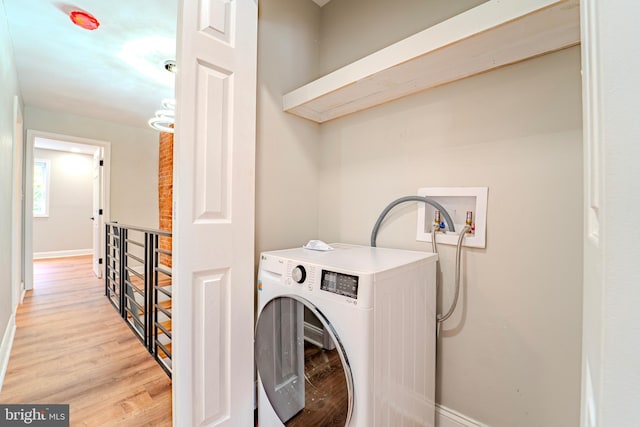 laundry room featuring light wood-type flooring and washer / dryer