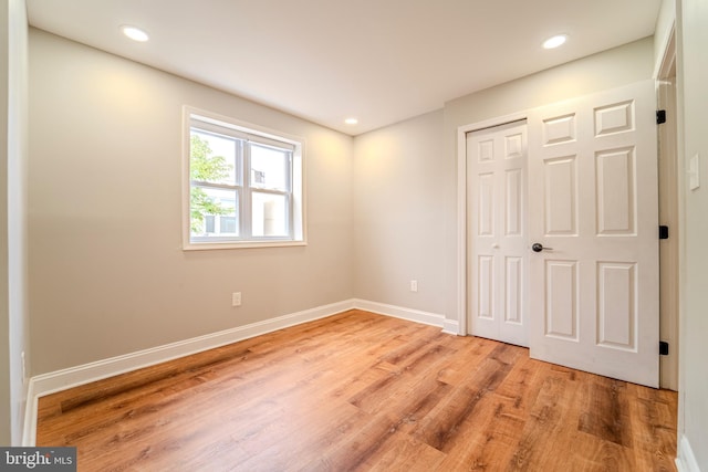 unfurnished bedroom with a closet and light hardwood / wood-style flooring