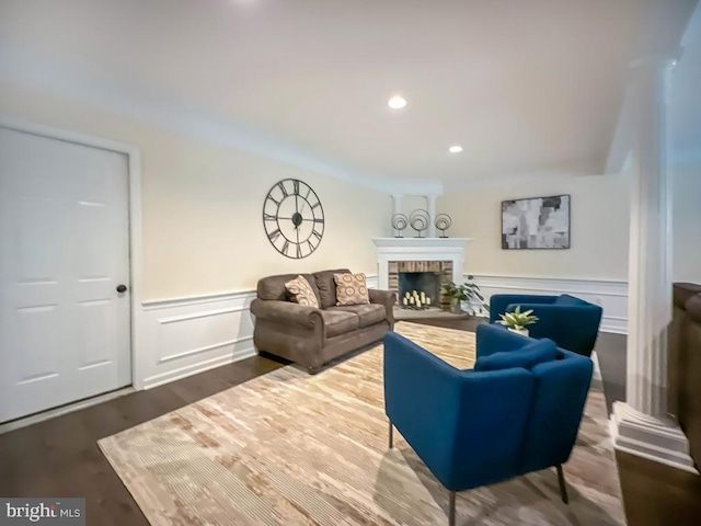 living room with a brick fireplace and hardwood / wood-style flooring