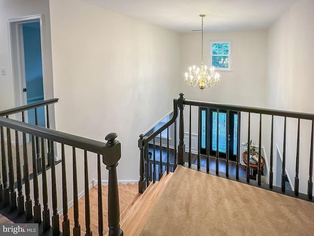 stairs featuring a notable chandelier