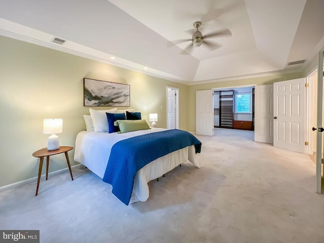 carpeted bedroom with ceiling fan and a tray ceiling