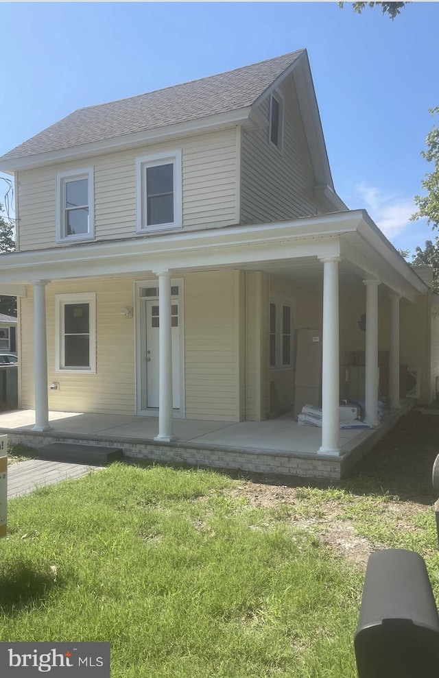 farmhouse featuring a front yard and covered porch