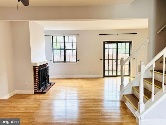 unfurnished living room with a healthy amount of sunlight, a fireplace, and light hardwood / wood-style flooring