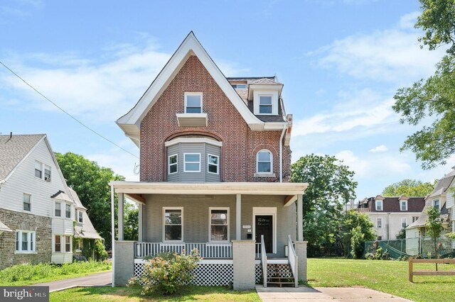 view of front of property with covered porch and a front lawn