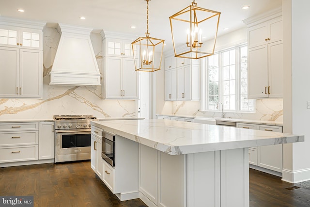 kitchen with appliances with stainless steel finishes, a kitchen island, decorative backsplash, dark wood-type flooring, and custom range hood