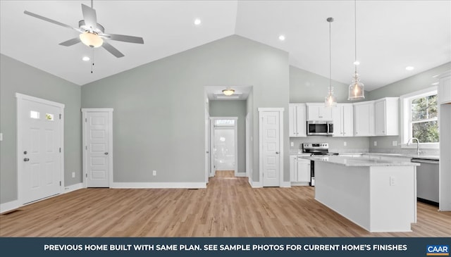 kitchen featuring a center island, appliances with stainless steel finishes, light hardwood / wood-style flooring, and white cabinetry