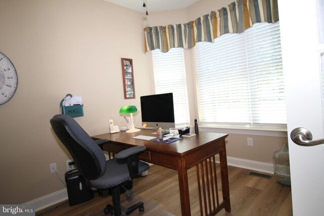 office with visible vents, baseboards, and wood finished floors