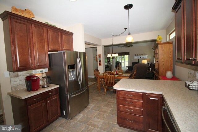 kitchen featuring a peninsula, stainless steel appliances, light countertops, open floor plan, and backsplash