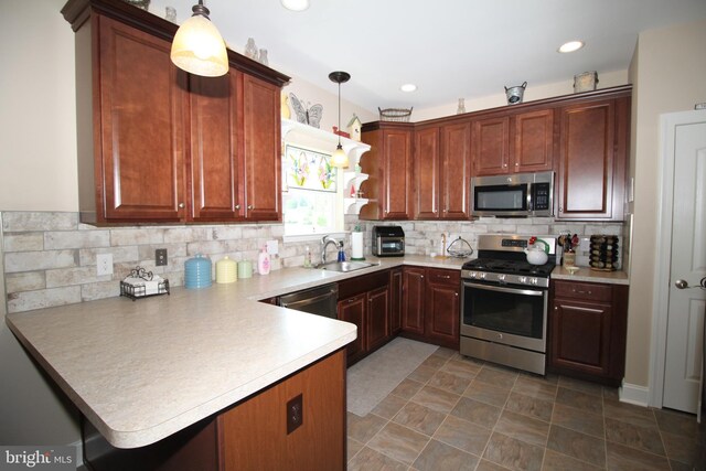 kitchen with a sink, tasteful backsplash, stainless steel appliances, a peninsula, and light countertops