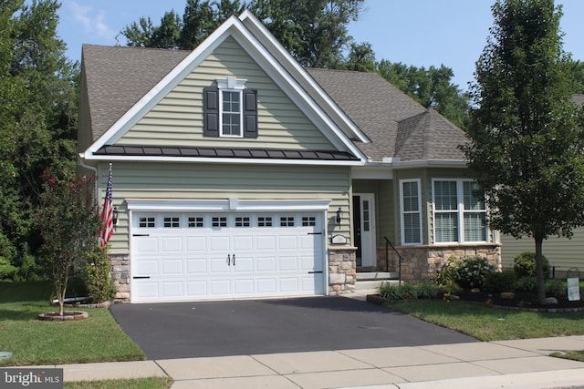 view of front of house featuring driveway, roof with shingles, a standing seam roof, stone siding, and metal roof