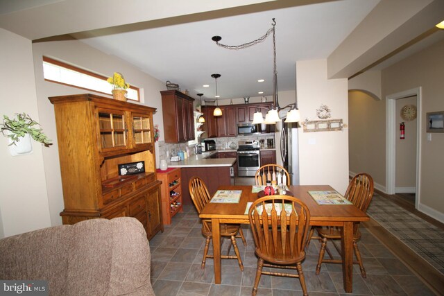 dining area with recessed lighting, baseboards, and arched walkways