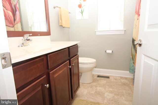 full bath with vanity, toilet, baseboards, and visible vents