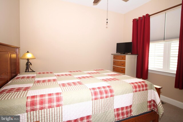 carpeted bedroom with a ceiling fan and baseboards