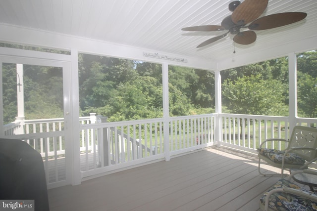 unfurnished sunroom featuring ceiling fan