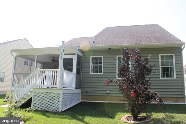 back of house with a yard, stairway, a shingled roof, and a sunroom