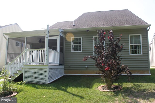 rear view of property with a yard, roof with shingles, and a sunroom
