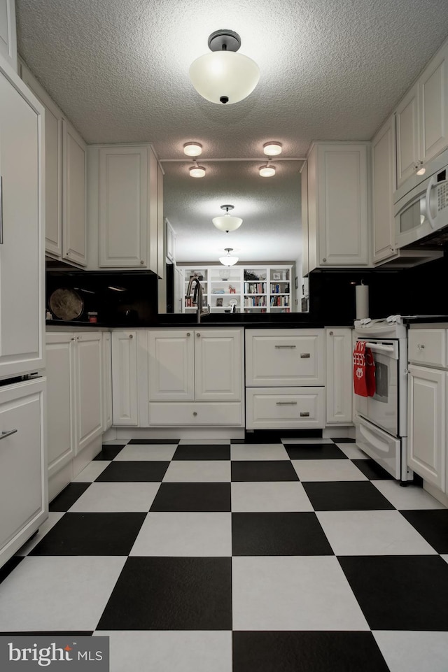 kitchen with white cabinetry, white appliances, sink, and a textured ceiling