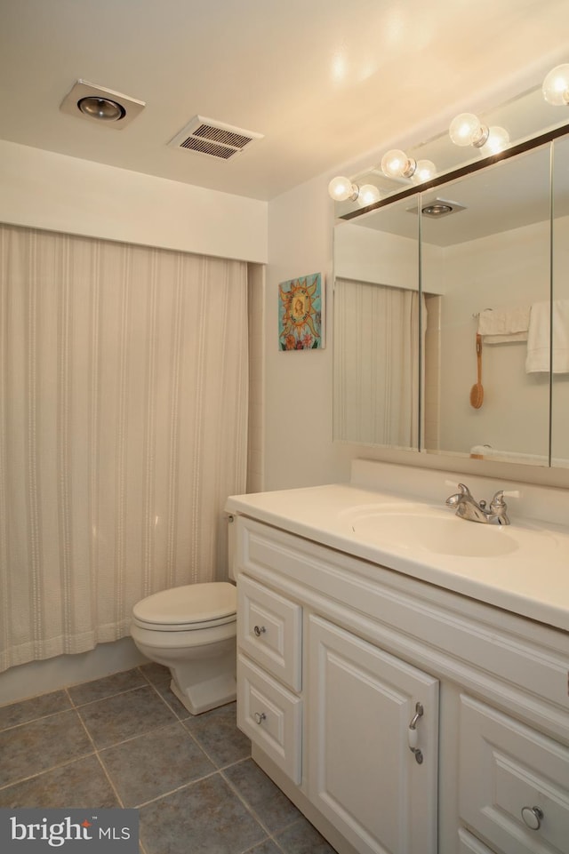 bathroom featuring vanity, toilet, and tile patterned flooring