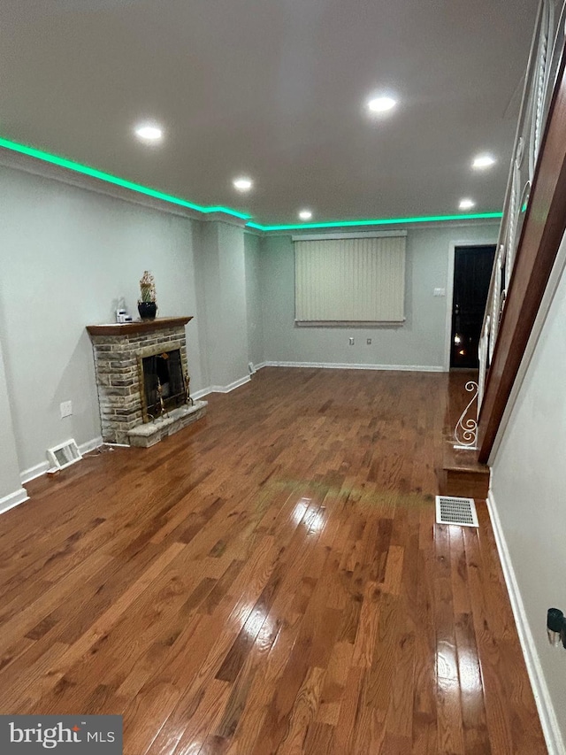 unfurnished living room featuring dark hardwood / wood-style flooring and a fireplace