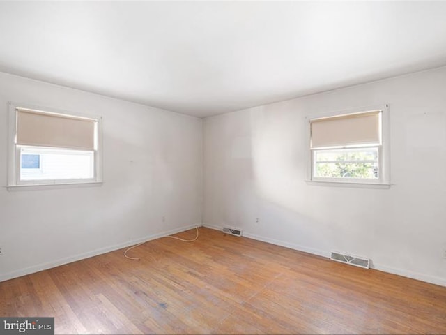 spare room featuring a healthy amount of sunlight and light hardwood / wood-style floors