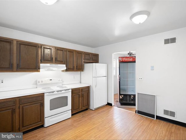 kitchen featuring light hardwood / wood-style floors and white appliances