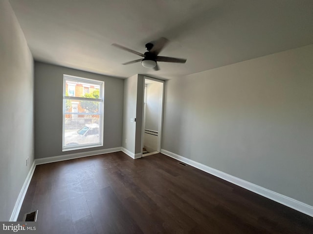 empty room with ceiling fan and dark hardwood / wood-style flooring