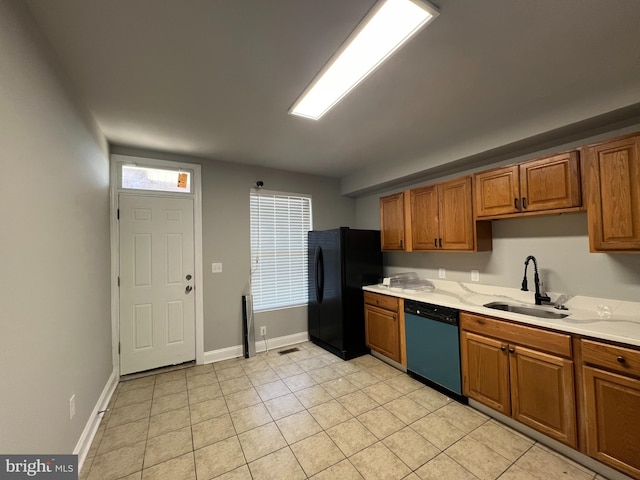 kitchen with sink, stainless steel dishwasher, and black refrigerator