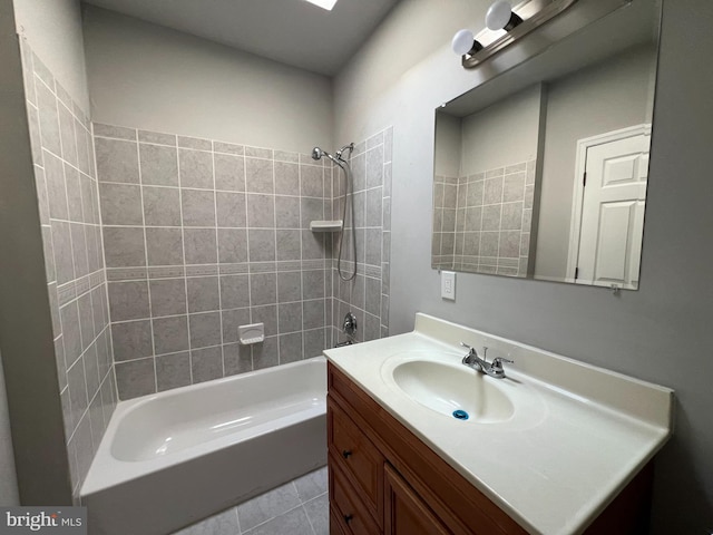 bathroom with tiled shower / bath combo, tile patterned flooring, and vanity