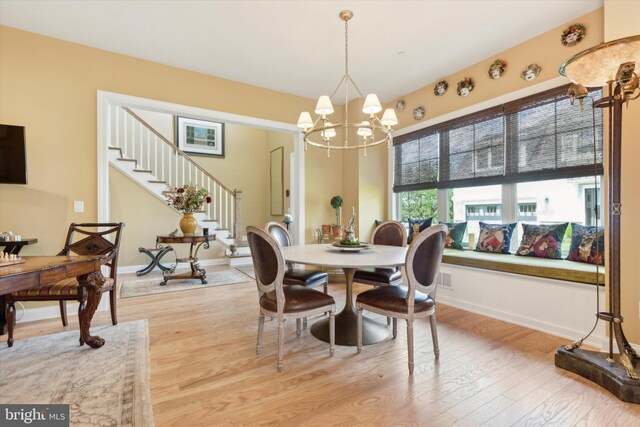 kitchen featuring a kitchen bar, appliances with stainless steel finishes, premium range hood, light hardwood / wood-style floors, and a kitchen island