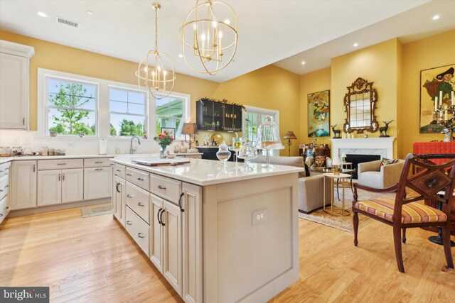 kitchen with a center island, a wealth of natural light, light wood-type flooring, and a high end fireplace