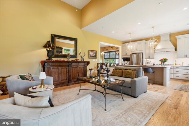 living room with a high ceiling and light hardwood / wood-style flooring