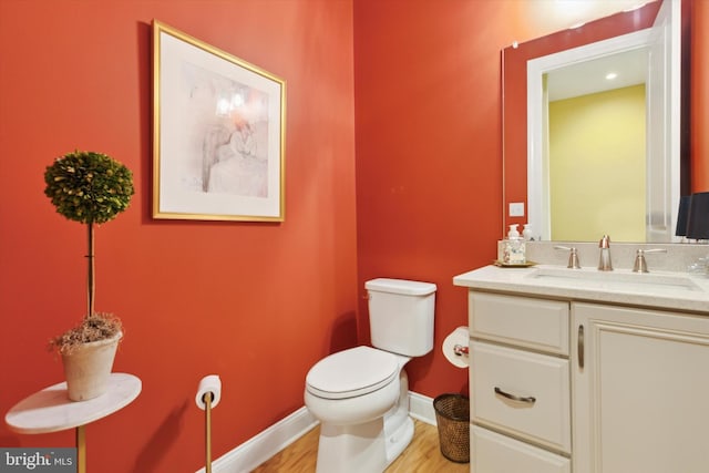 bathroom with wood-type flooring, toilet, and vanity