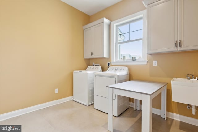 clothes washing area with sink, cabinets, washer and dryer, and light tile patterned floors