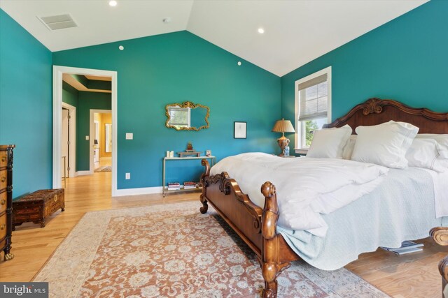 bedroom with lofted ceiling and light hardwood / wood-style floors