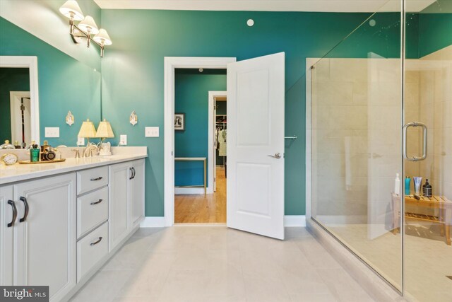 bathroom featuring a shower with shower door, vanity, and hardwood / wood-style flooring