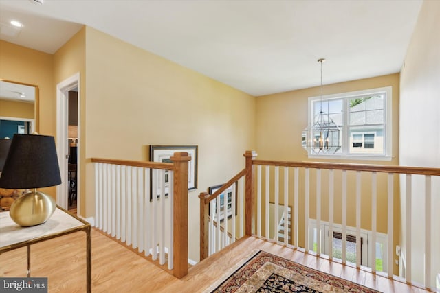 staircase featuring an inviting chandelier and wood-type flooring