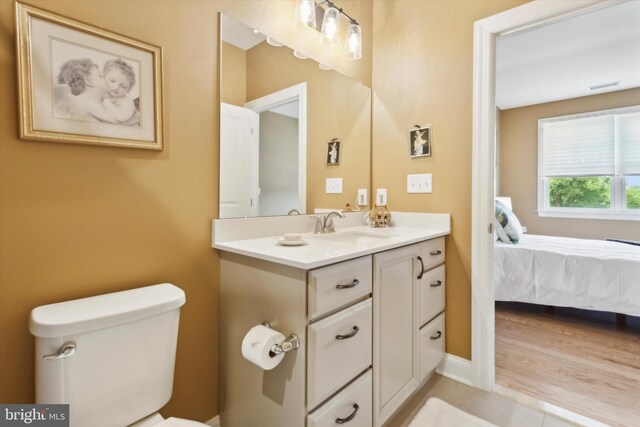 bathroom featuring hardwood / wood-style floors, vanity, and toilet