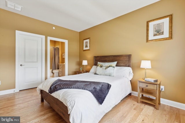 bedroom with light hardwood / wood-style floors and connected bathroom