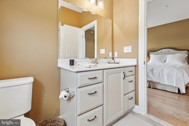 bathroom with hardwood / wood-style floors, toilet, and vanity