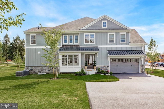 view of front of home with a garage, central air condition unit, and a front yard