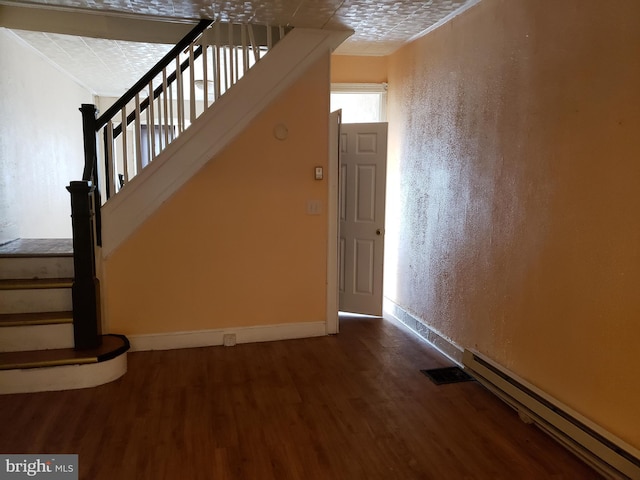 stairway with hardwood / wood-style floors and a baseboard radiator