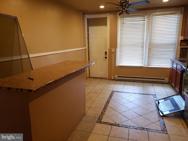 kitchen featuring ceiling fan, a wealth of natural light, a baseboard heating unit, and light tile patterned flooring