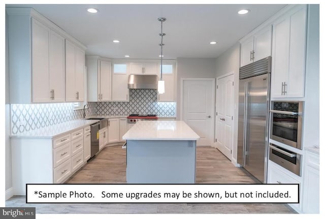 kitchen with backsplash, pendant lighting, a center island, stainless steel appliances, and white cabinets