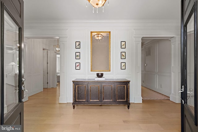 hallway featuring ornamental molding and light hardwood / wood-style floors