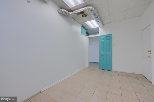 tiled spare room featuring a paneled ceiling