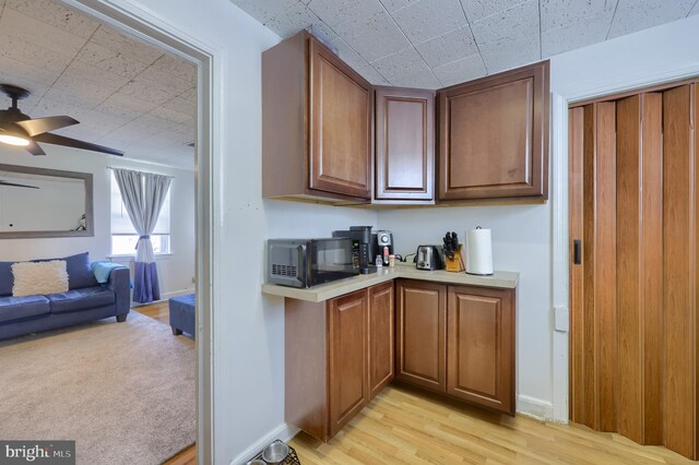 kitchen featuring ceiling fan and light carpet